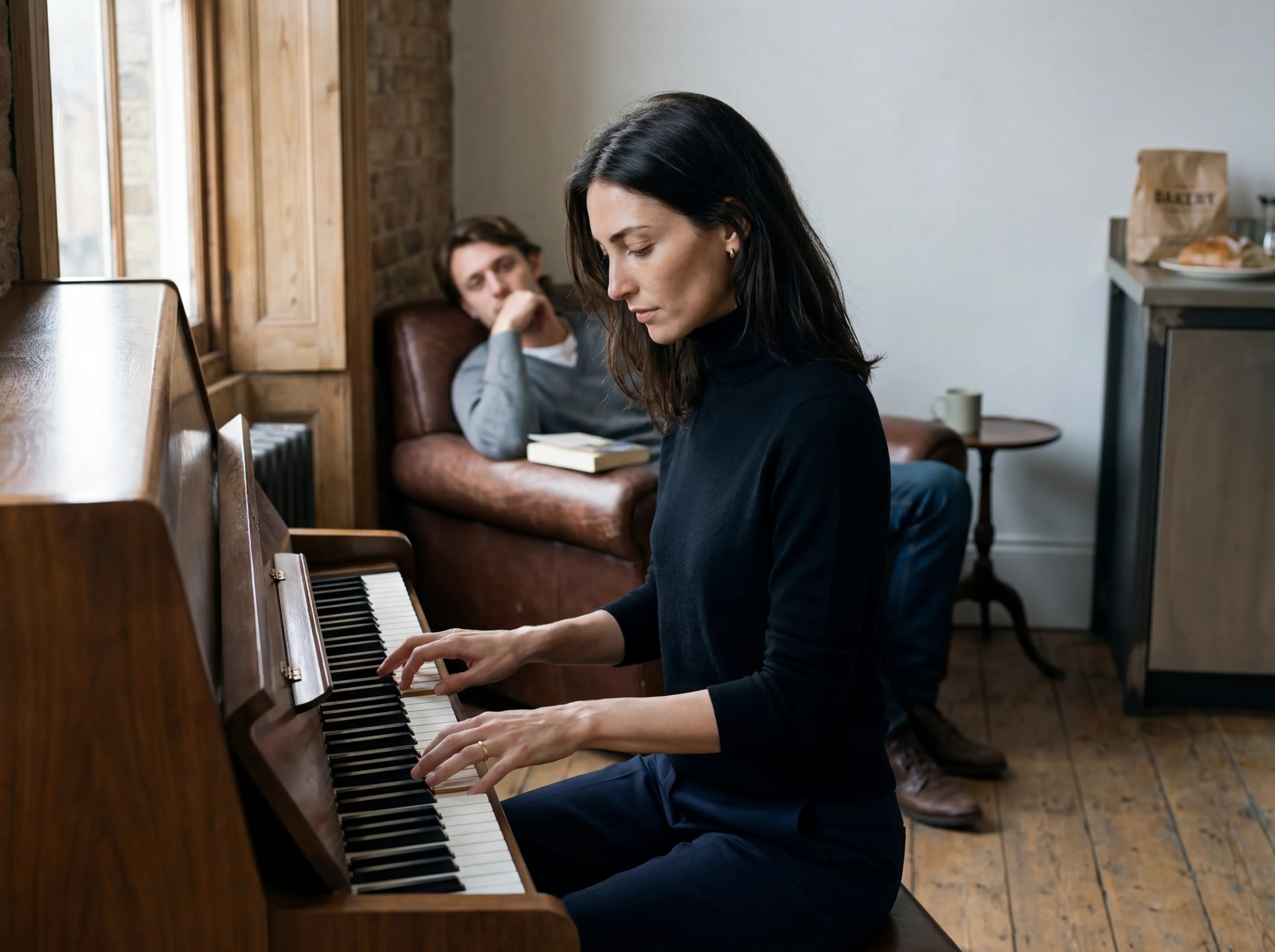 Iris Lambert at a grand piano, her hand resting on the open lid.