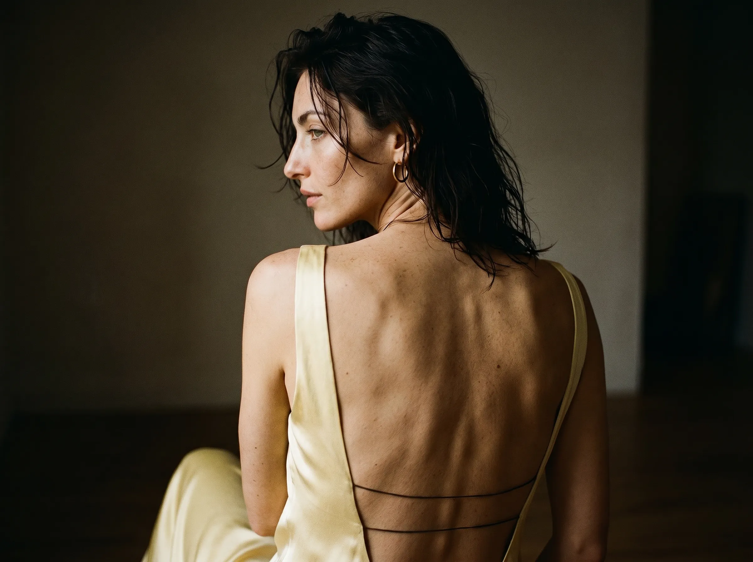 Iris Lambert, sitting in a backless gold dress.